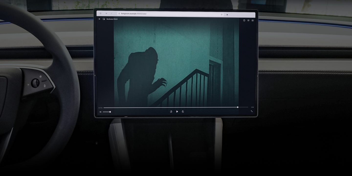 Hi, bye playing Nosferatu (1922) full screen in the browser on the center touchscreen of a Tesla Model Y, seen from beside the steering wheel in a dark cabin.